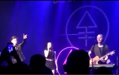 Christina Grimmie's band giving the 'devils horn' and its logo in the background, the alchemical symbol for phosphorous, which is commonly associated with Lucifer in occult circles.